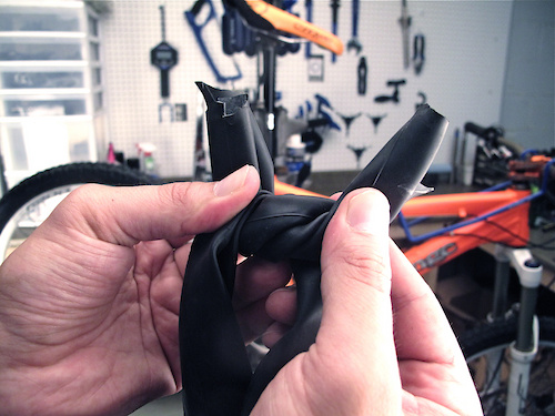 It is important to have enough slack to easily tie the two ends together in a tight knot, but at the same time you don't want to use so much tube length as to make reinstalling the now too-small tube back on the wheel difficult. Again, the tighter the knot is, the better chance you'll have at getting out of the bush.