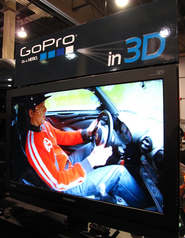 Part of GoPro's booth included a DVD loop of footage collected from their new 3D setup. The 3D Hero Housing fits two of the 1080p cameras side-by-side which feed together using a sync cable kit. GoPro has slated the unit for release early next year.