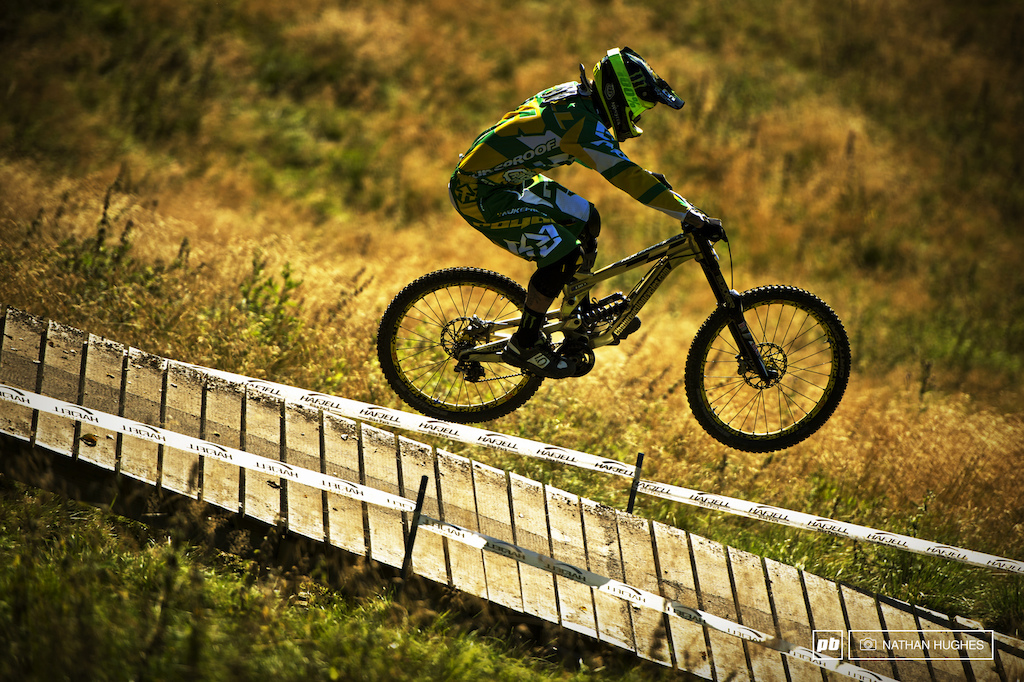 The gold and green figure and bike of Sam Hill camouflaging itself perfectly into the gold and green of the Hafjell terrain on the last run of practice.