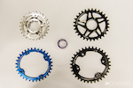 Located about 4 minutes from QBP HQ here in Minneapolis is Wolf Tooth. They cut their teeth on making narrow wide chain ring options very early in the SRAM 1 x 11 game and their two latest offerings keep in that vein: Eliptical wide narrow (called "Drop Stop") chainrings for better pedaling ergonomics and stainless steel Drop-Stop chainrings for increased durability. They also have nice anodyzed headset spacers. What we see here are (clockwise, top left): 28T SRAM Direct Mount 426 stainless Drop Stop chainring, an elliptical alloy 30T Drop-Stop Race Face compatible direct mount  (Cinch) chainring, an XT compatible 34T Drop-Stop alloy 96 BCD chainring, and an anodyzed blue 32T 104 BCD Drop-Stop elliptical ring. Why Elliptical? Reutedly, elliptical rings deliver a smoother cadence for more reliable power transfer.