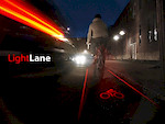 Light Lane is projected from the bike, behind the bike.
Story here
http://radek.pinkbike.com/blog/lightlane.html