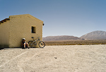 Despite its 2850m/9400 ft altitude, riding in Argentina's Los Cardones Park means getting up early to avoid the midday heat. This desolate cabin was the only shade for miles, providing a short breather.

Photo by Dan Milner
