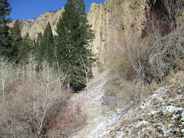 Looking back up the trail along "The Wall".  About a half mile long rock wall along the trail. Probably about 200-300 feet high.  A real cool place, the trail is sandwiched between the wall and the creek on a scree slope. It will test your riding ability.