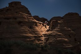 Thomas Vanderham riding slick rock lines in Southern Utah illuminated with remote strobe on drone heli.