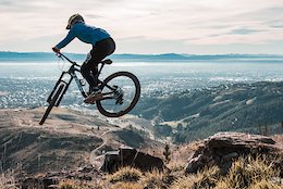 Lui steezes his way over small rock drop/step down on the amazing Throw the Goat trail at the Christchurch Adventure Park with views over Christchurch City and the Mountains in the distance...