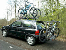 4 bikes and 3 persons with gear