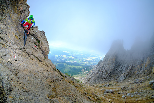Riding down a steep rock section while descending from the Latemar Spitze in the Dolomites.