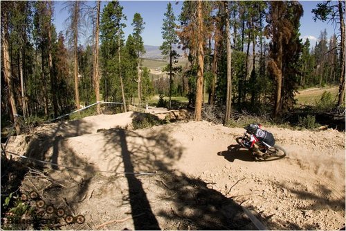 A grom dwarfed by the monster berms on Ashy Larry trail