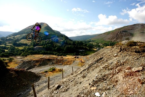 Old shot of Gee on virgin hit of huge huck near his home in Wales. He lands over the ridge at the bottom left of shot.