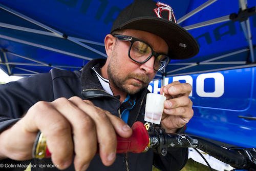 Shimano Tech rep Ryan Gaul plumbing the depths of Luke Strobel's Saint Brakes. "the little plunger I'm using kind of works like a toilet plunger: I squeeze the lever, and then use the little plunger to pull out any stray air bubbles."