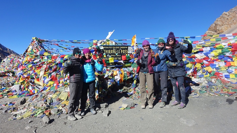 World Ride participants and guide Usha are all smiles after topping out on Thorong La Pass (5416m, 17,769 ft), the highest point on the Annapurna Circuit.