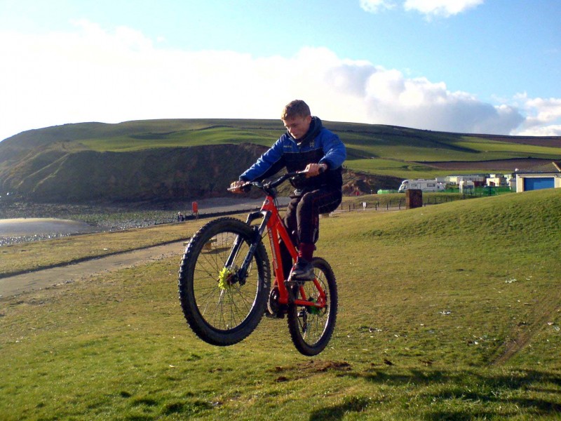 alex doing the jump at the beach on stix's bike