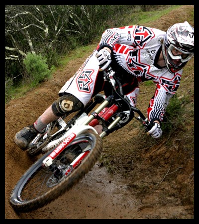 Steve Peat swinging through a muddy berm