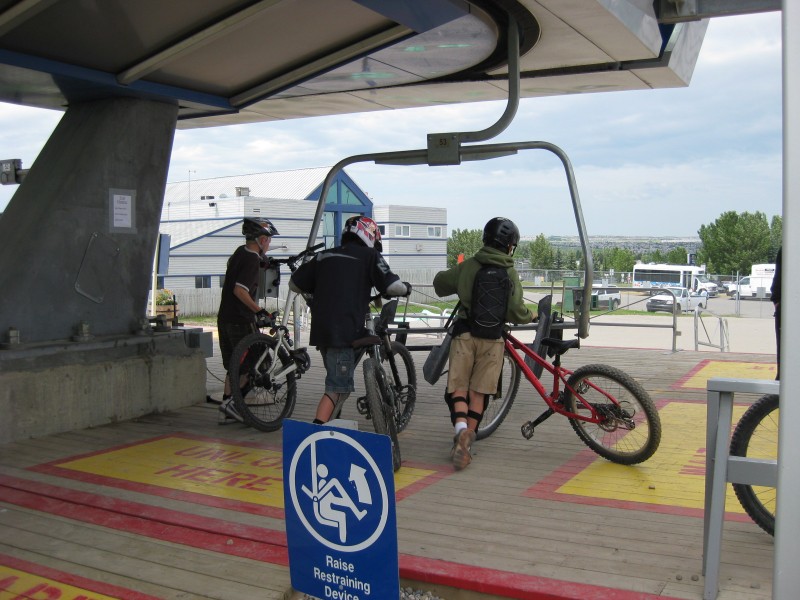 COP-riders load their own bikes up on the lift.