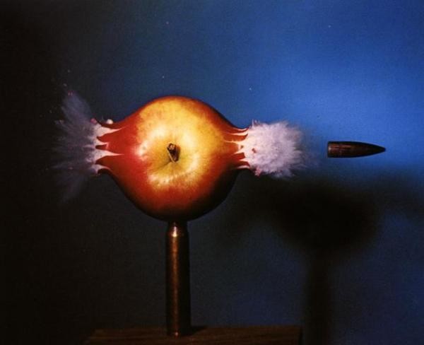 A picture takin of a bullet shooting an apple by a high speed camera.