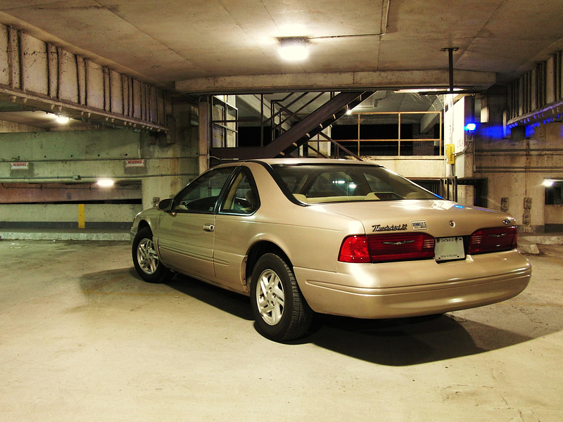 My 1997 Ford Thunderbird LX. (last year they were made in a coupe, before that fugly convertible was made). 

I got bored and went shooting my car at my old school and at my friend's work at night. :)