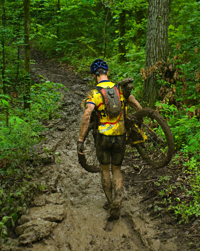 A raider carries his bike through the mud at Dirt, Sweat, and Gears, 2009.