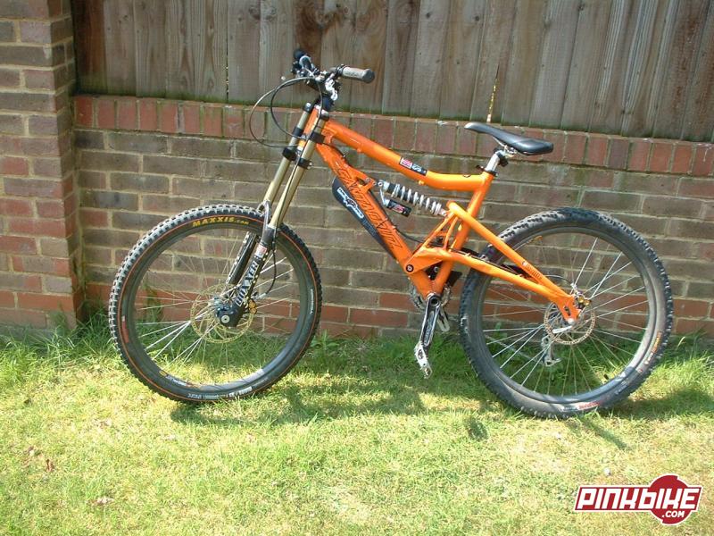 Overview -
Santa Cruz Bullit Frame Orange Medium, RockShox Boxxer Race Fork 170mm, Mavic 729 rims laced to Hope Bulb front XC Rear, Maxxis Minion Tyre Front 2.35 60A Dual-Ply, Nokian DH Inner Tubes, Hope Mono M4s front and rear 200mm & 160mm, RaceFace Evolve Stem 50mm (not pictured), Easton EA70 Bar medium rise (not pictured), unbranded seatpost and seatclamp, Scott Voltage Seat, Sram X.9 Shifter and Mech, Shimano Dura-Ace Chain, Shimano XT Cassette, WTB Weirwolf Rear Tyre 2.5, Avid Flak Jacket Gear Set, RaceFace Diabolus Crankset, with Truvativ Box Guide 2, V12s in XTR Grey