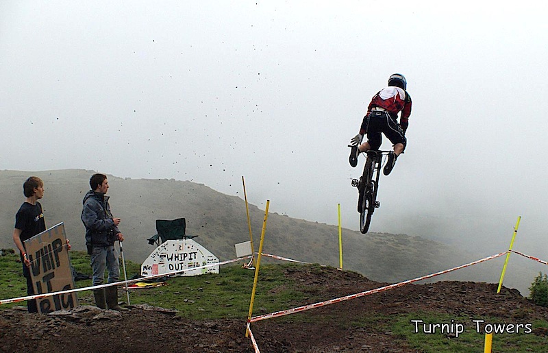 I thought this new jump near the top at Moelfre Hall might look quite spectacular with the misty background. I was hoping for a shot of a rider doing a big whip, but the jump was kicking back wheels up and causing lots of nose landings. Then Alun Lewis came down, shot straight up in the air, struggled out of his clips, did a big star jump over the bars and disappeared over the edge of the hill. I was so shocked I forgot the first rule of photography - keep shooting! I really thought he would be in bad shape, but he pushed back up the track a couple of minutes later. Although I missed what could have been a good sequence, I like the fact that I managed to catch the moment when everything is going wrong and me, the spectators and the rider are just waiting to see what happens next.