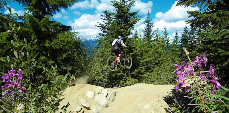 Another dusty day in Whistler, boosting off the second jump on Side Track.  Nice little composition by sam there with the flowers on each side!