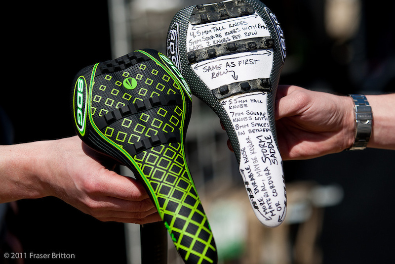 SDG's production I-Fly Storm saddle next to the first prototype made by Sam Hill's mechanic, Jacy.<br><br><span style='font-size:19px'>SDG I-Fly Storm saddle details:</span><br><br>- I-Fly saddle shell<br>- Two versions: aggressive and less aggressive<br>- Tread is injection molded onto the saddle's cover<br>- Features a one piece stitch-less cover.