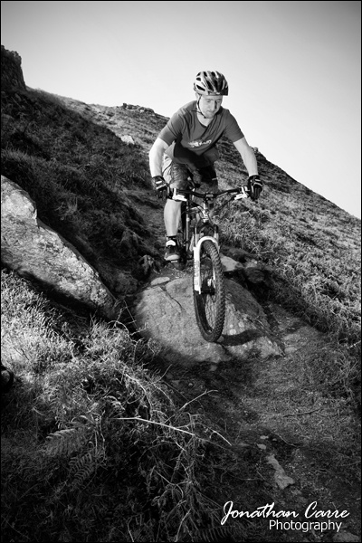A self portrait session up the Sychnant Pass in North Wales. I had the radio remote shutter clasped to my grip. I was triggering the remote shutter with my index finger and braking with my middle. It was awkward anyway, and then the two different radio signals (one controlling the shutter, one controlling the off camera flash) started interfering. The way round this ended up being setting the camera for a two-second delay, this stopped the remote shutter interfering with the remote flash but left me having to judge when I was two seconds from the place I wanted to occupy in the image, triggering the shutter and then two seconds later (with me hopefully in the right position) the camera would fire with the off camera flash and hey presto!