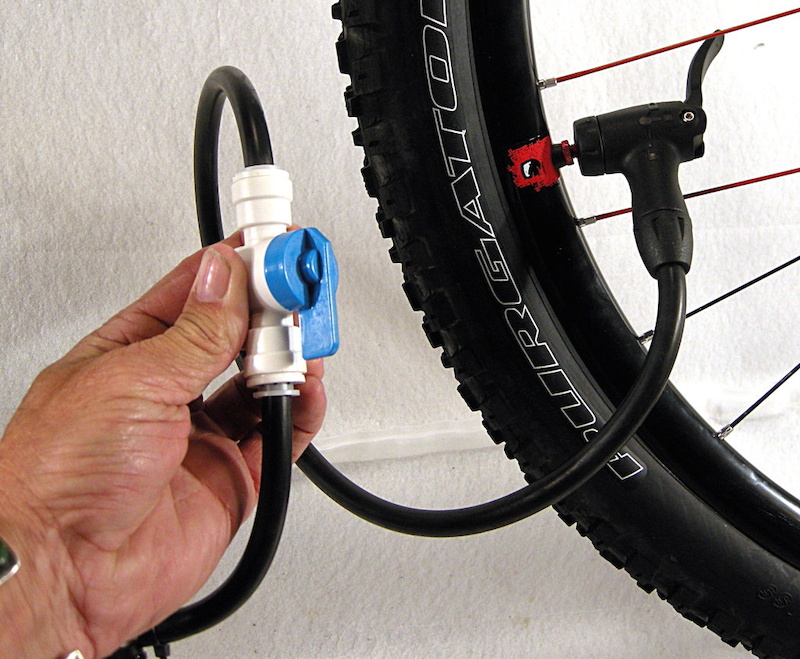 Open the valve and inflate the tubeless tire. Once air is flowing you are free to manipulate the bead where it has not sealed on the rim.