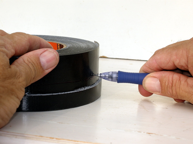 Brace the pen with your hand against a table so that the tip lines up with the mark on the tape and then spin the tape roll to mark the entire circumference.