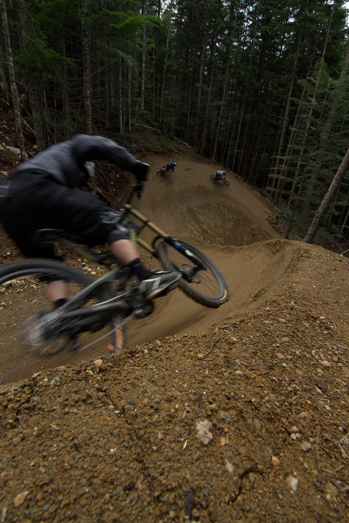 A group of friends shred A-Line's new double berm on the final weekend of operation at Whistler Mountain Bike Park.