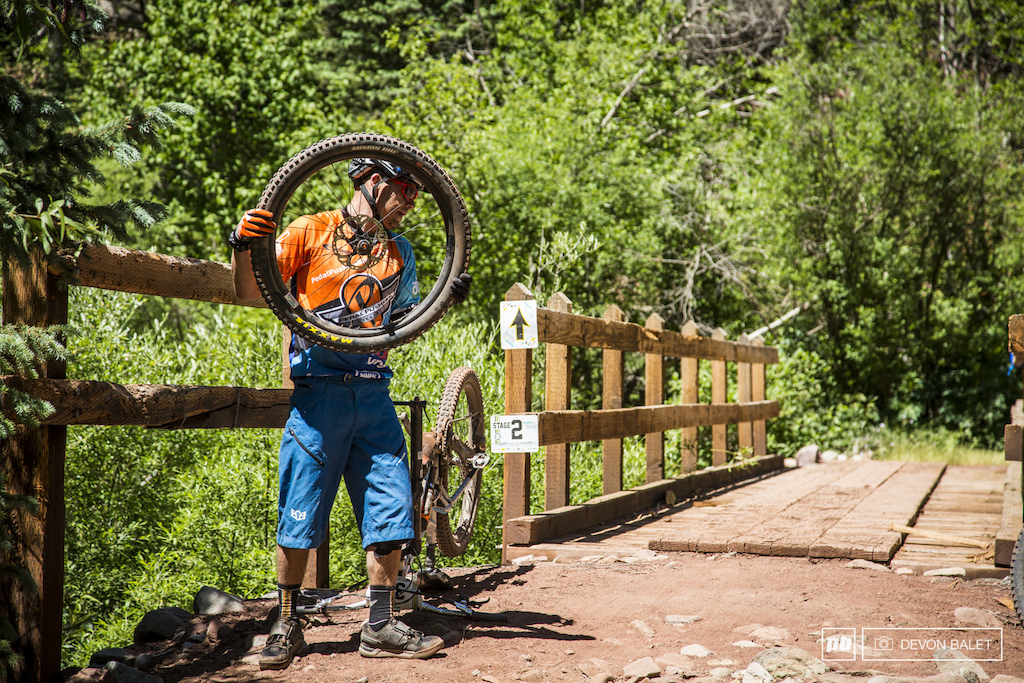 An all too common scene at the bottom of stage one. Stage one tested your riding and equipment to the max and was sure to find a weak point. Cole Trout seals up a slow leak on his front tire.