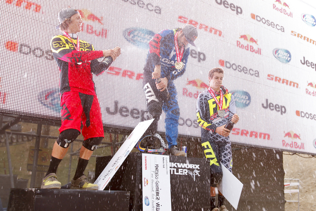 On the podium, Matt Wallace 3rd place, Nic Beer 2nd place and Marcelo Gutierrez in 1st place pop the champagne bottles.