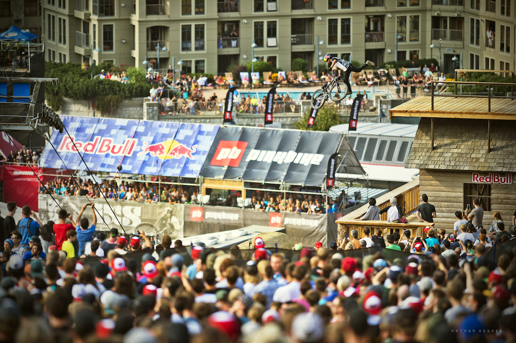 Yannick Granieri tail whips down into the bottomless crowds of Crankworx Whistler 2014. Copyright: Nathan Hughes
