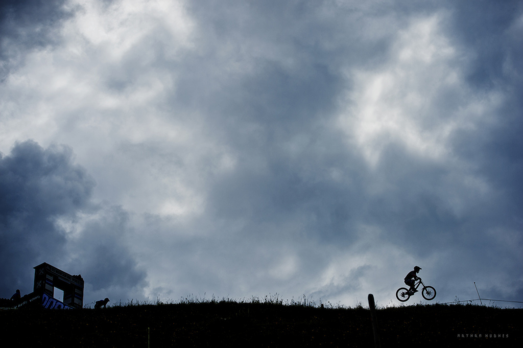 ET phone Austria. A silhouetted racer finds the first air of the Leogang WC track. Copyright: Nathan Hughes