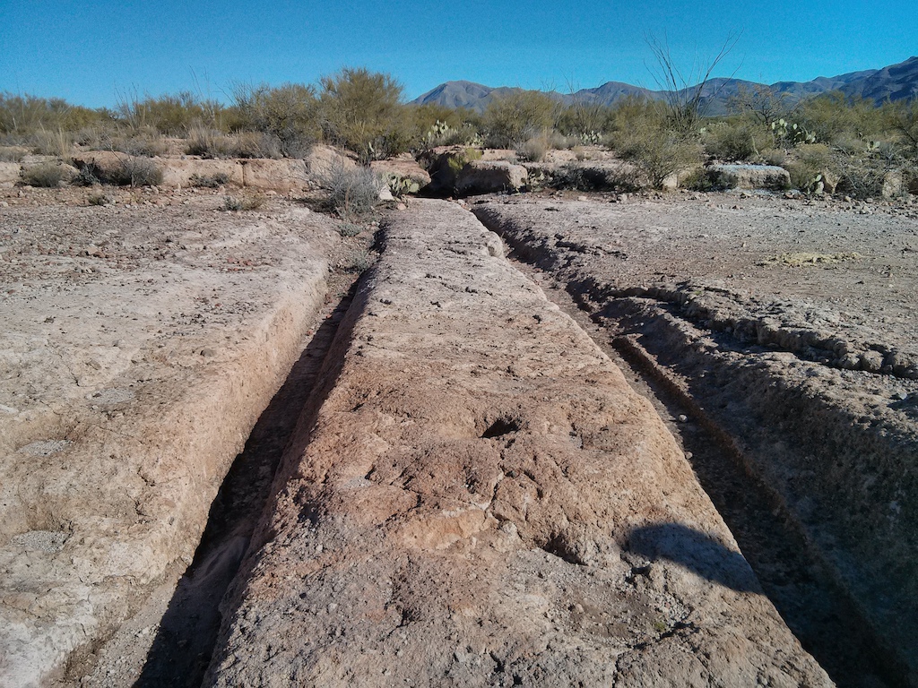 Old wagon tracks through stone (volcanic tuff).  Formed in the late 1800's by hauling loads from Silver King mine to the nearby King Mill in the short-lived mill town of Pinal (1877-1891).