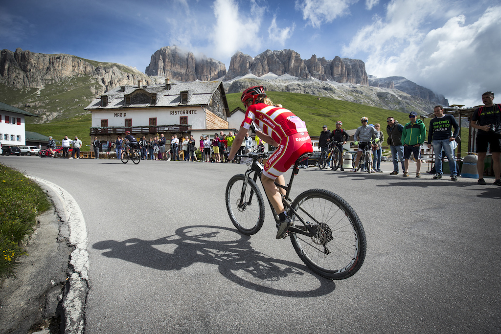 Perfect spot for spectators: Annika Langvad on her way to „Passo Pordoi". In the back the scenic rock towers of the „Sella".
