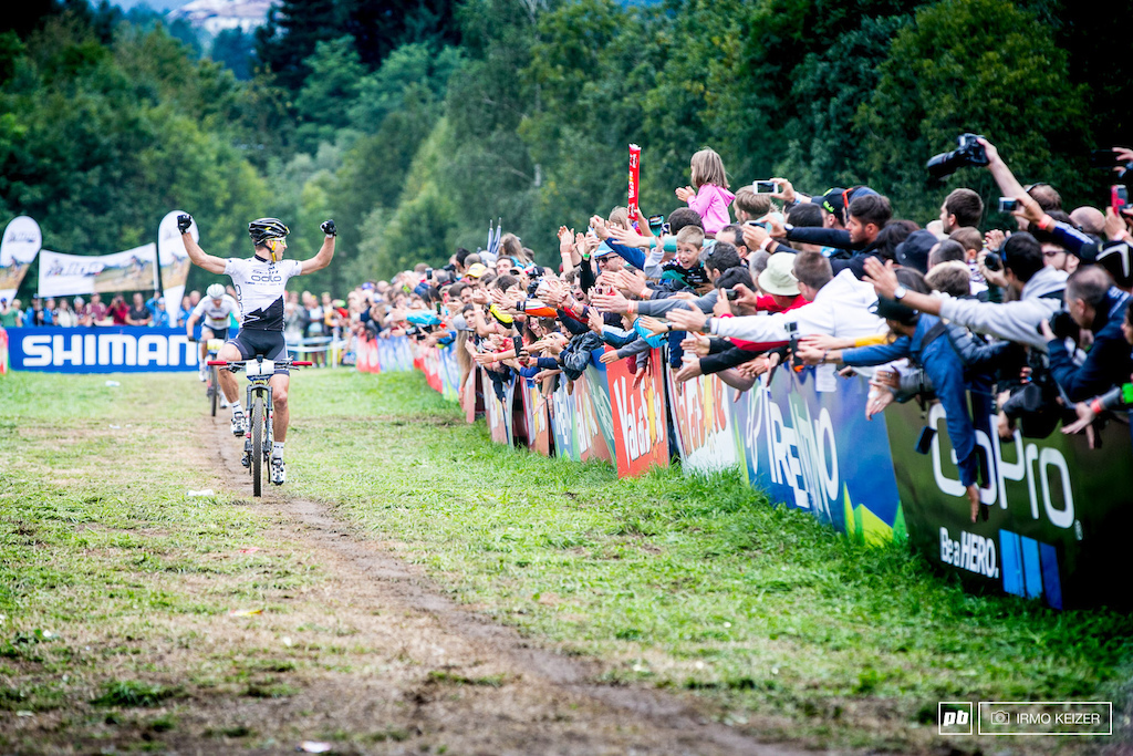 Nino Schurter looks over his shoulder, raising his arms as a win is certain.