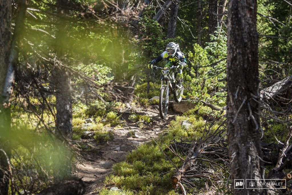 Stage five sent racers onto Mountain Goat a fun but technical trail in the deep woods. The opening section of the trail is no big deal but later on things get more interesting. Christine Irelan airs into the start of Mountain Goat.