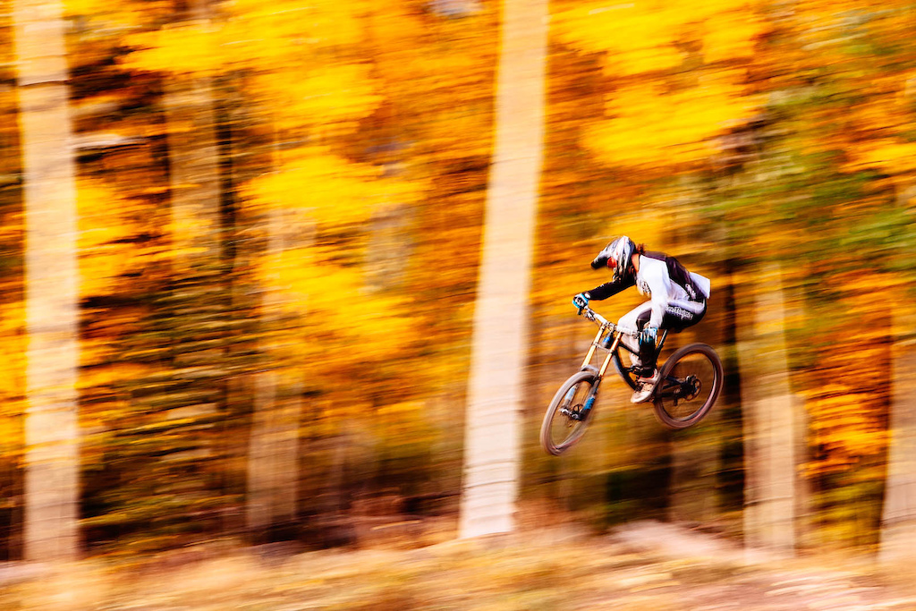 Brandon flies through blazing aspens in the late afternoon light at the Mountain Village Bike Park.