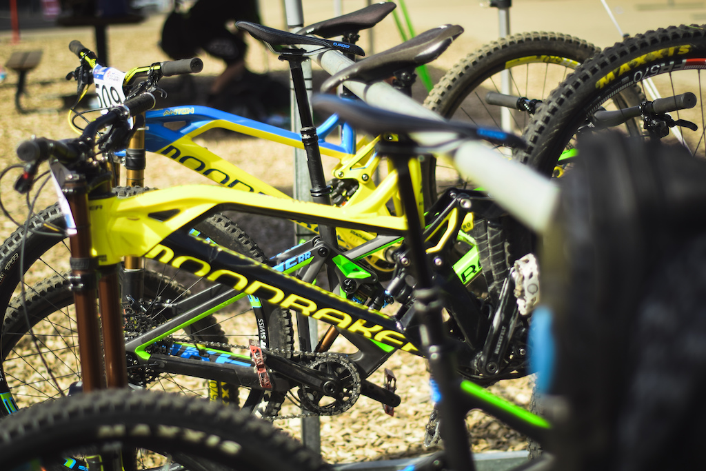 Countless Mondraker Summum's hanging on a ski rack in the pits