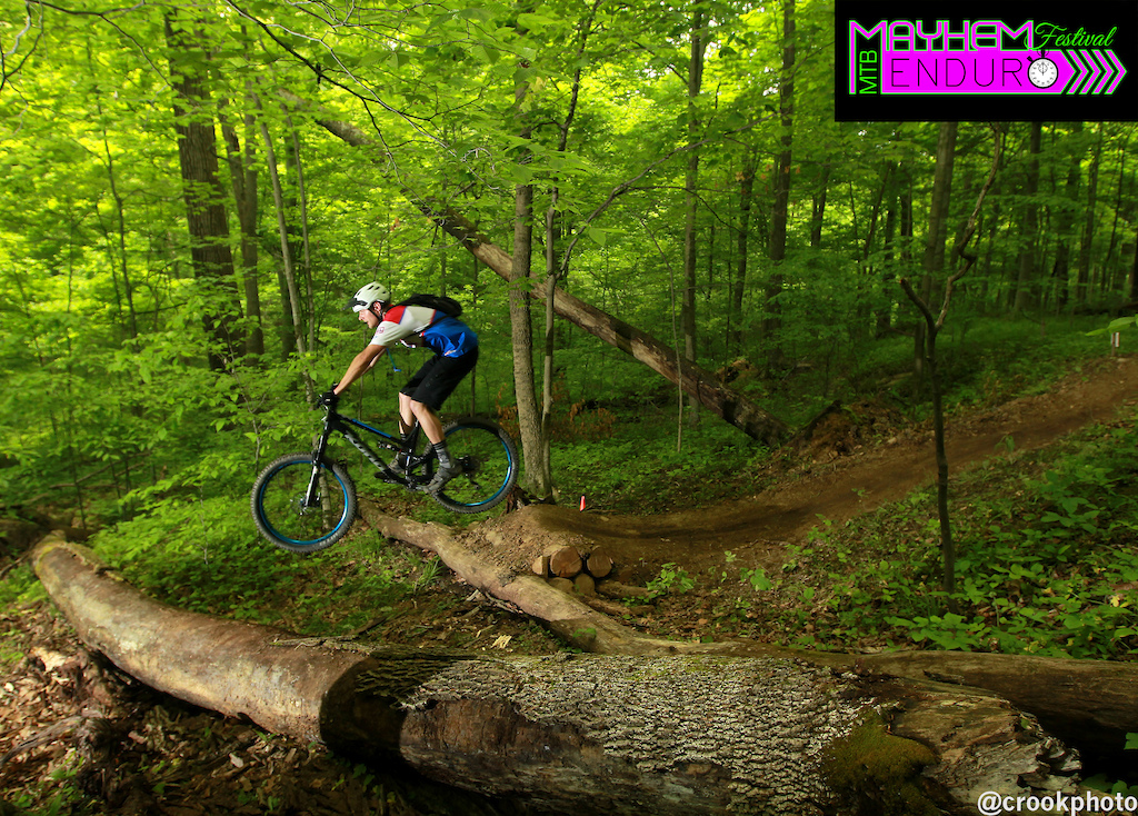 Riders clear a jump near the end of the fourth stage of the 2016 Mayhem Enduro in Cumberland, Ohio on May 29, 2016.