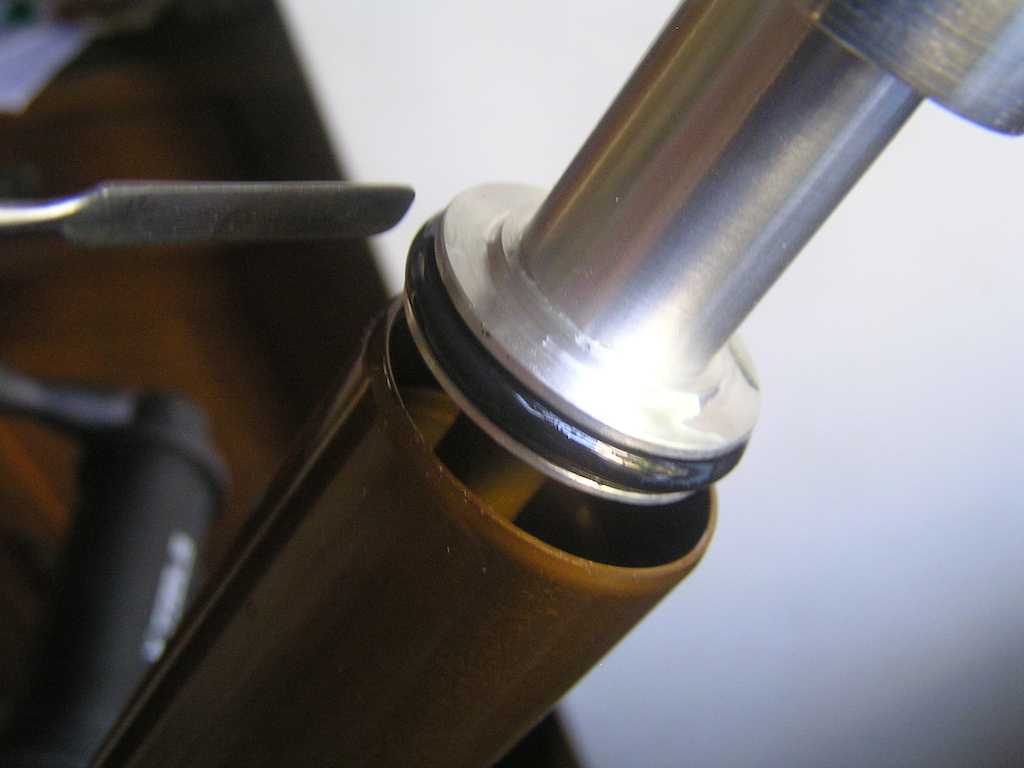 Lubricating lower O-ring and gently pushing it into the stanchion, taking care not to cut it on the edge