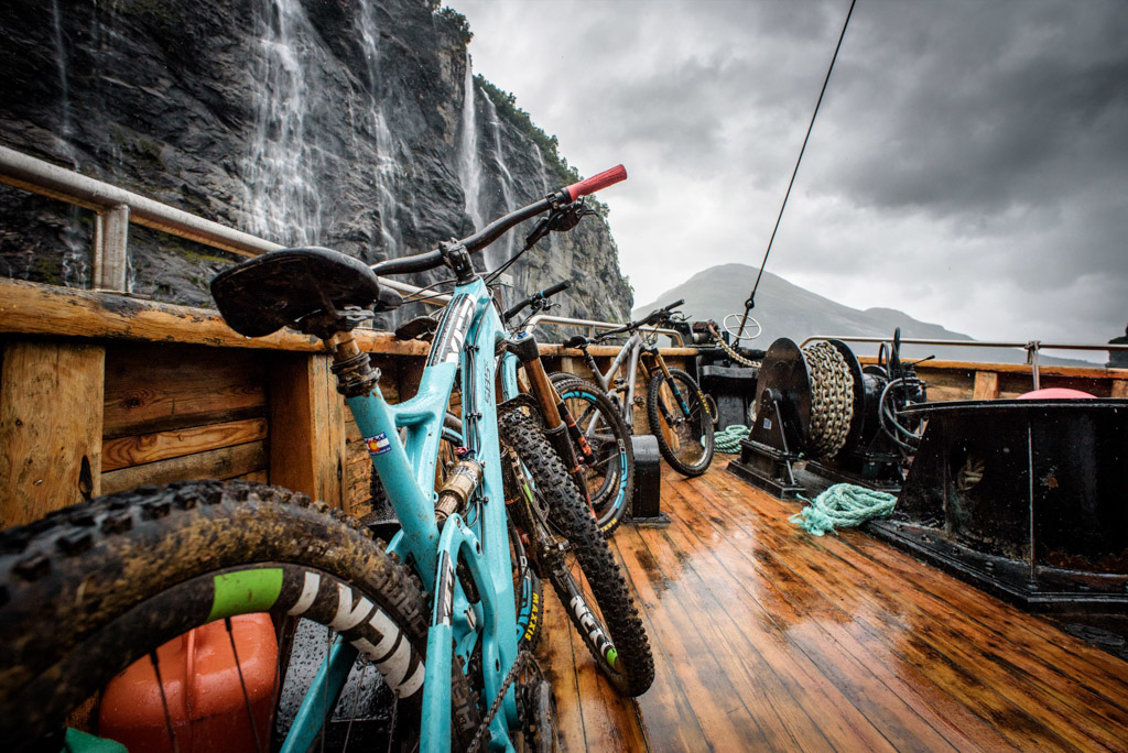 Bikes and boats dwarfed by the sheer fjord walls