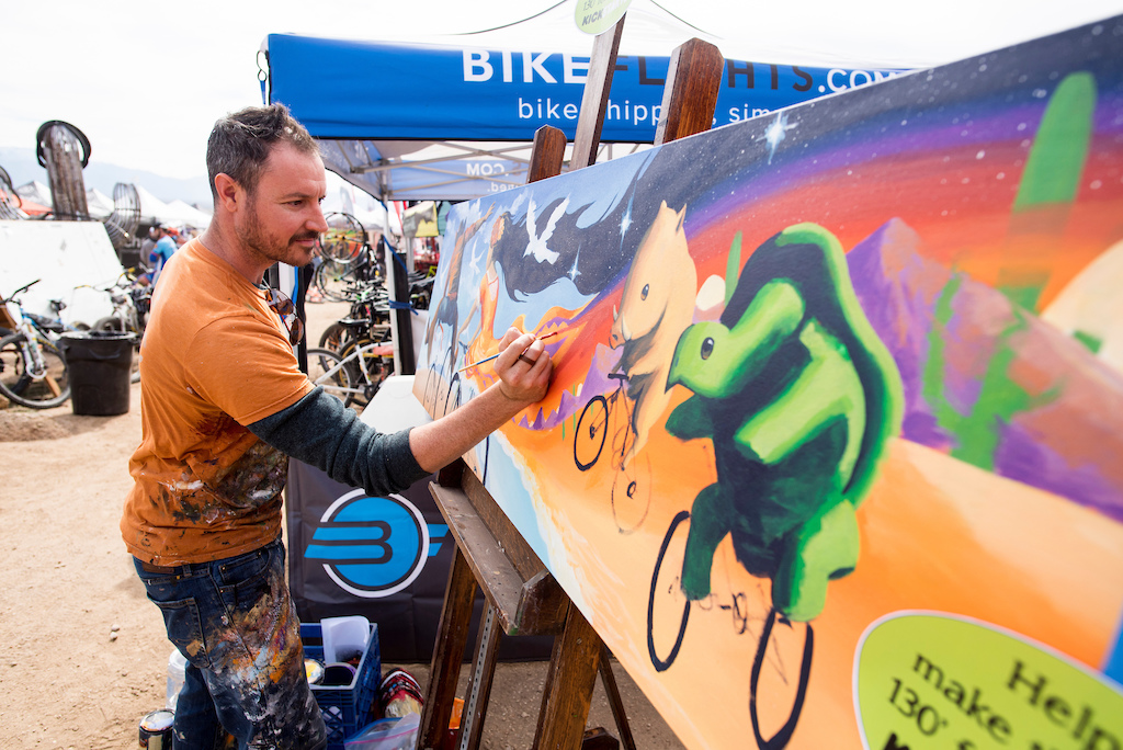 An expo vendor paints to help raise money for a Kickstarter project at the Bike Expo on Friday.