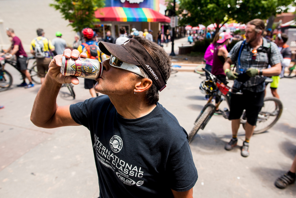 A racer takes a deep swig of beer after finishing his ride Saturday.