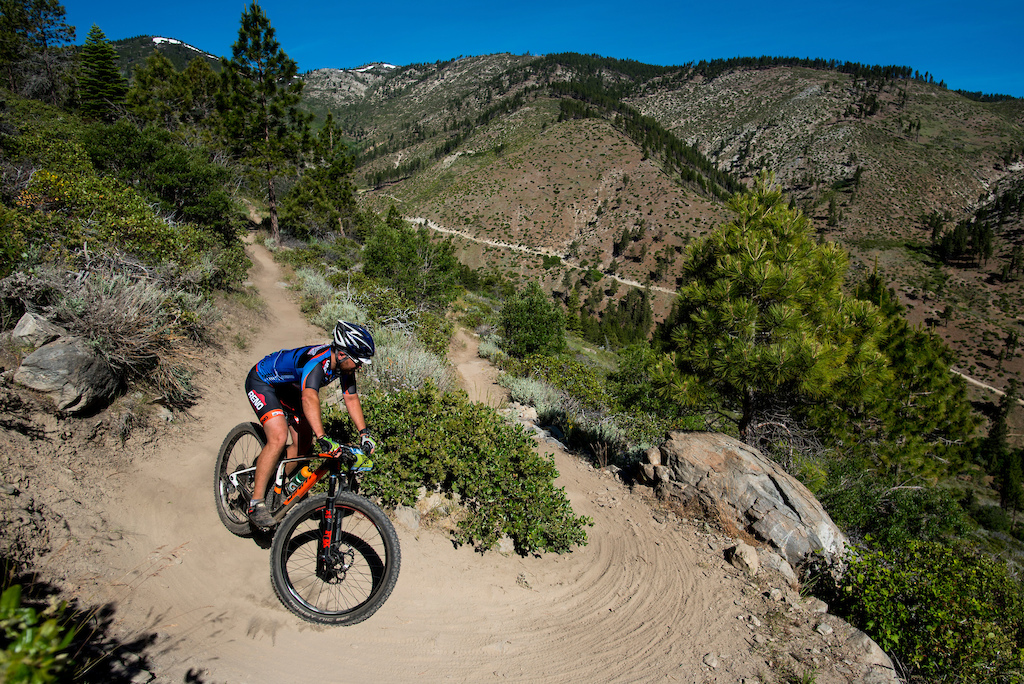 A racers rounds  switchback while descending the Ash to Kings trail.