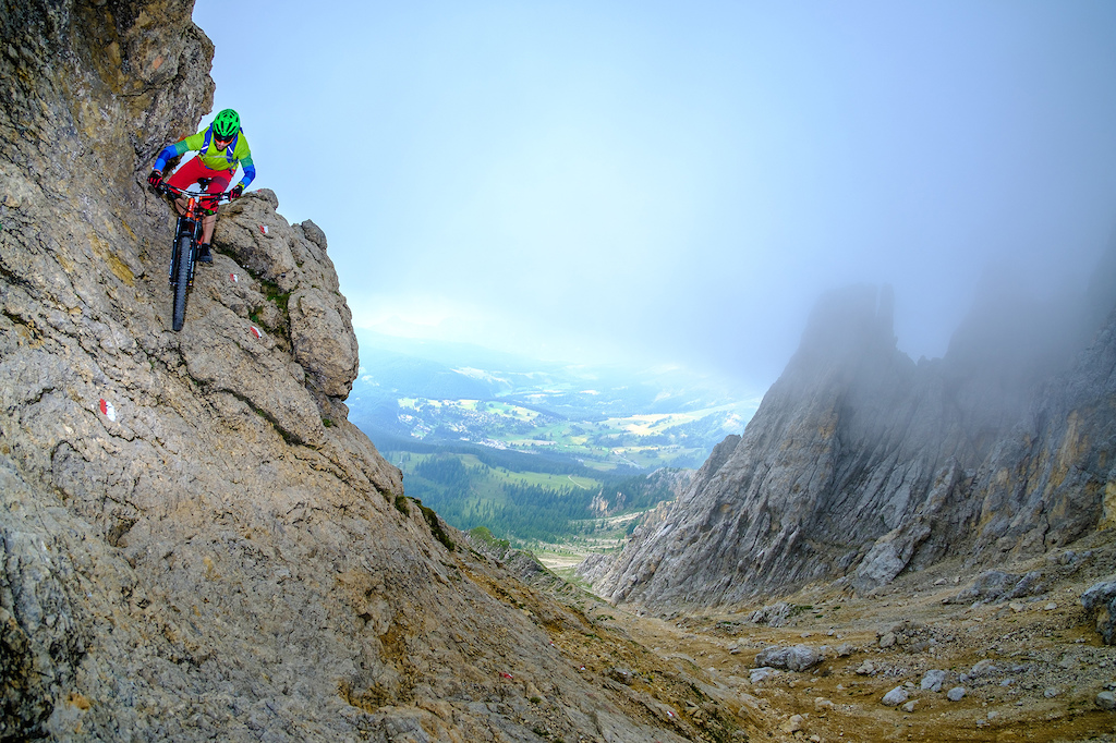 Riding down a steep rock section while descending from the Latemar Spitze in the Dolomites.