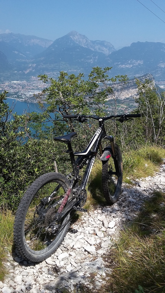 my bike on the coast trail at the lake Garda - Riva del Garda in the background