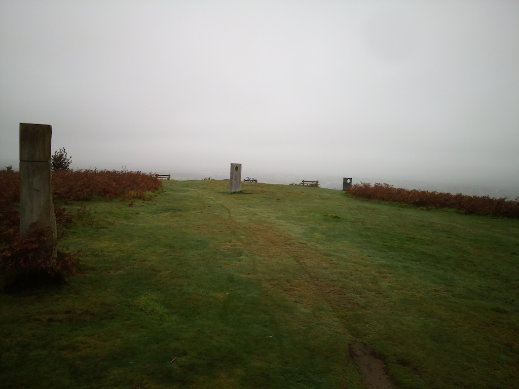 3 Standing Stones with holes in them and 3 benches facing the view. Useful to locate starts of trails.