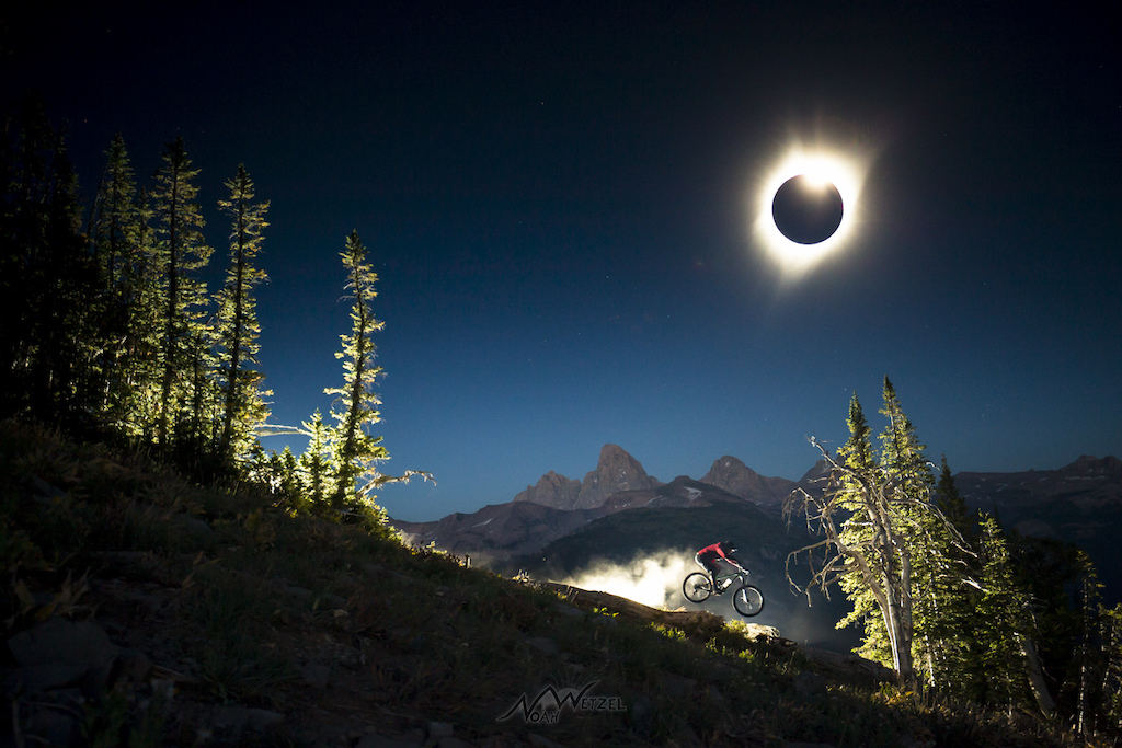 Chris Brule charges off a natural feature underneath the Grand Teton on the Total Solar Eclipse, August 21st in Teton Valley, Wyoming.
