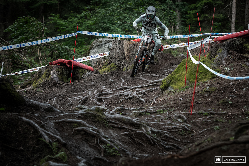 Loris Vergier attempts to point it to the inside over all the slick roots despite the fact that they are covered in a fresh coat of rain.